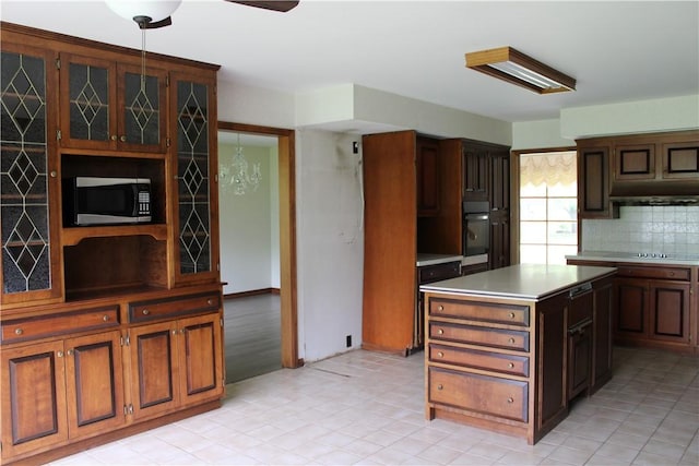 1011 W N 3rd St, Shelbyville, IL 62565 - kitchen with stainless steel microwave, oven, under cabinet range hood, light countertops, and a center island