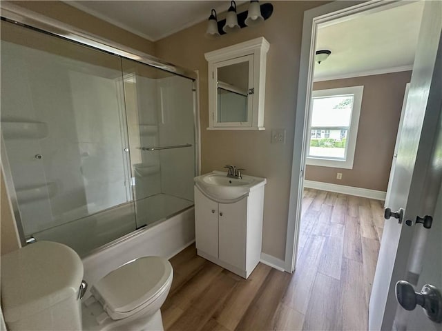 126 E Elliott St, Paris, IL 61944 - bathroom with crown molding, vanity, wood finished floors, and enclosed tub / shower combo