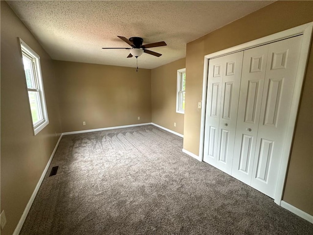 126 E Elliott St, Paris, IL 61944 - unfurnished bedroom featuring carpet, a textured ceiling, a closet, and ceiling fan