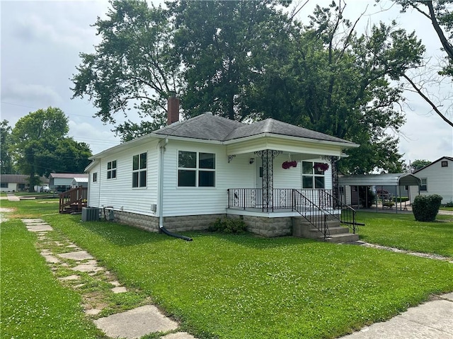 126 E Elliott St, Paris, IL 61944 - view of front of property featuring covered porch, a front lawn, a chimney, and a detached carport