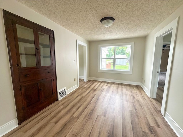126 E Elliott St, Paris, IL 61944 - spare room with light wood-style flooring and a textured ceiling