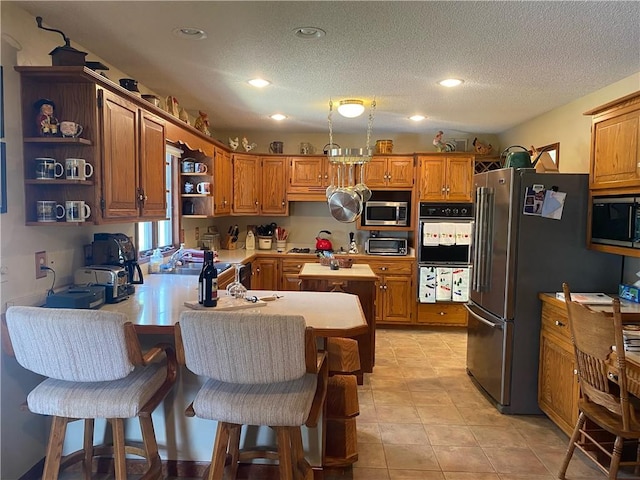 303 S Pine St, Pana, IL 62557 - kitchen with stainless steel appliances, open shelves, a sink, a peninsula, and light countertops