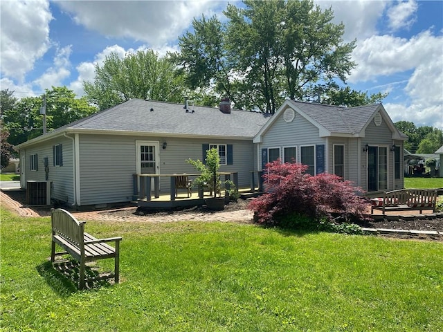 303 S Pine St, Pana, IL 62557 - back of property featuring a wooden deck, a yard, central AC unit, and roof with shingles