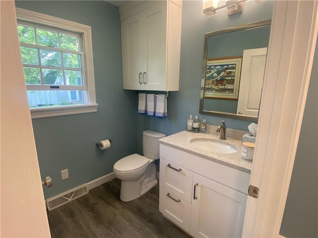 303 S Pine St, Pana, IL 62557 - half bathroom featuring wood finished floors, vanity, toilet, and baseboards