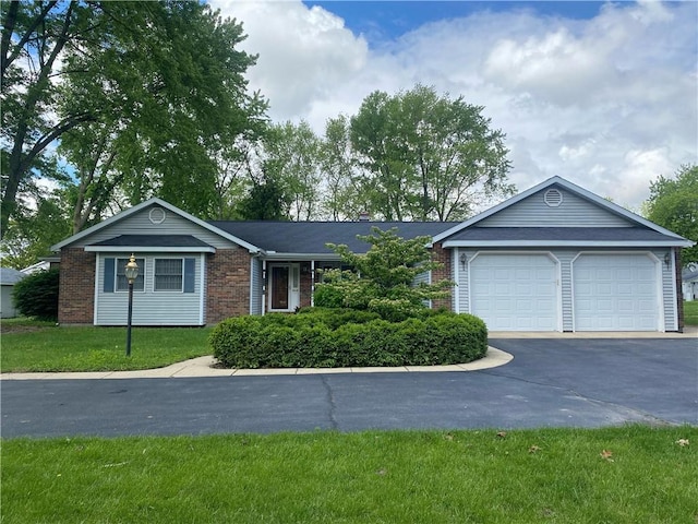 303 S Pine St, Pana, IL 62557 - single story home with driveway, brick siding, a garage, and a front lawn