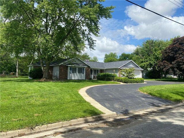 303 S Pine St, Pana, IL 62557 - single story home with brick siding, a front lawn, asphalt driveway, and an attached garage