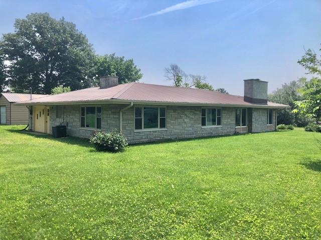 900 W Cumberland Rd, Saint Elmo, IL 62458 - rear view of property with a chimney, stone siding, a yard, and a metal roof