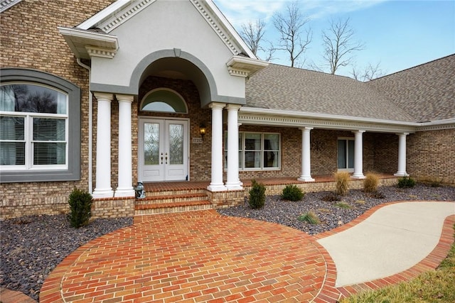 17212 Stonecreek Dr, Effingham, IL 62401 - view of exterior entry with brick siding, french doors, a porch, and roof with shingles