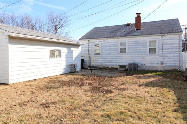 back of house featuring central AC unit, a patio area, and a lawn