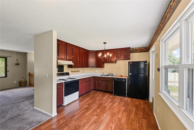 2701 E Rd, Danville, IL 61832 - kitchen with black appliances, under cabinet range hood, a chandelier, light countertops, and wood finished floors