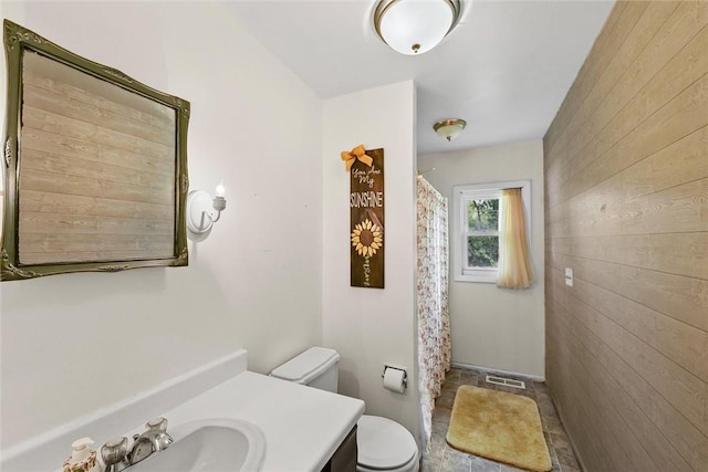 2701 E Rd, Danville, IL 61832 - bathroom featuring wooden walls, vanity, and curtained shower