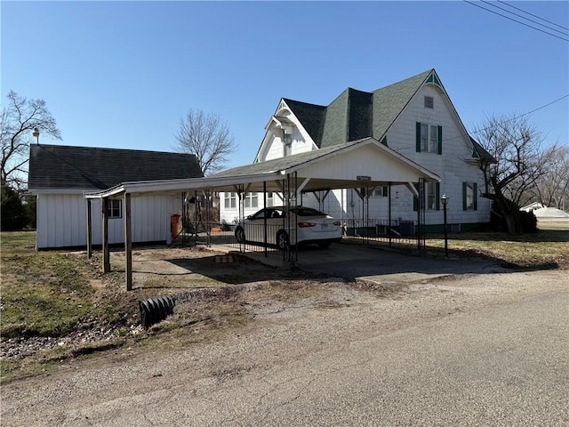 view of front facade with driveway and a shingled roof