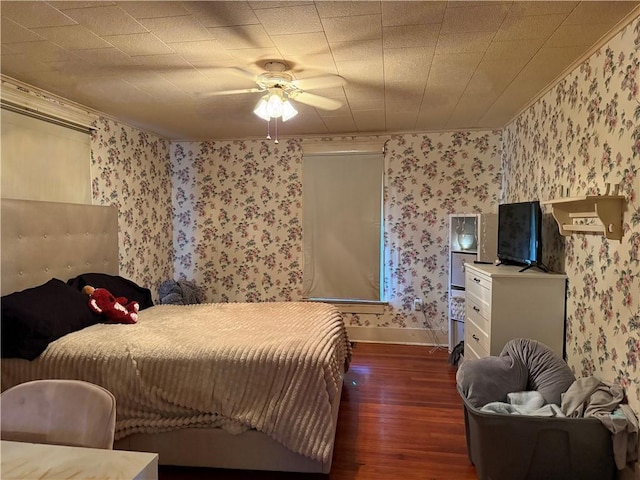 bedroom featuring a ceiling fan, wallpapered walls, baseboards, and wood finished floors