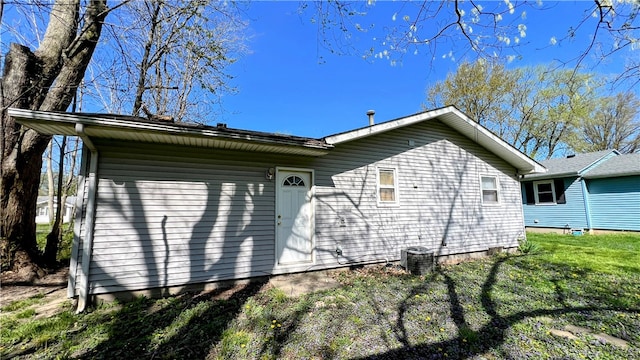 rear view of house featuring a yard and central air condition unit