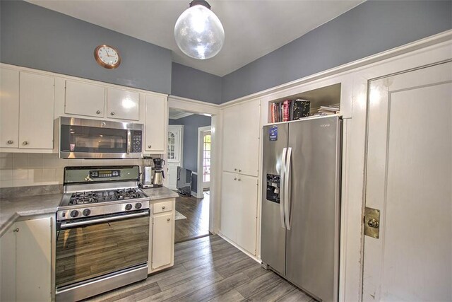 2064 William St, Decatur, IL 62522 - kitchen with stainless steel appliances, white cabinetry, backsplash, wood finished floors, and light countertops