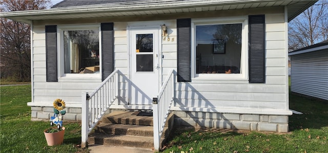 view of exterior entry with a lawn