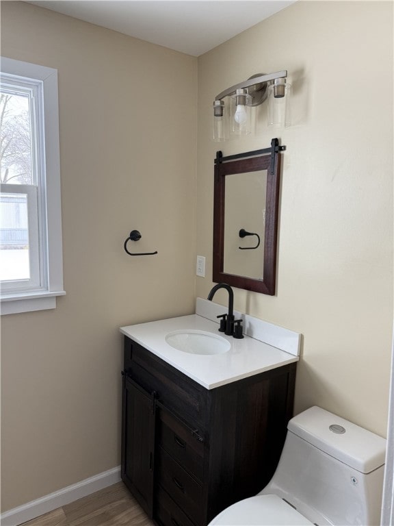 bathroom with vanity, toilet, and wood-type flooring