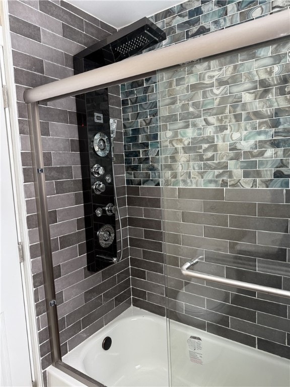 bathroom featuring combined bath / shower with glass door