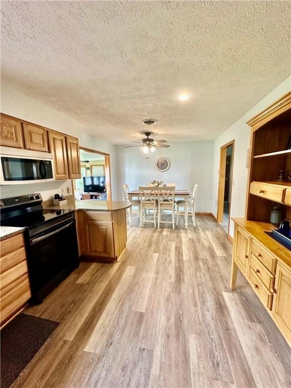 31508 1800 E Rd, Rossville, IL 60963 - kitchen with electric stove, a textured ceiling, a peninsula, light wood-type flooring, and ceiling fan