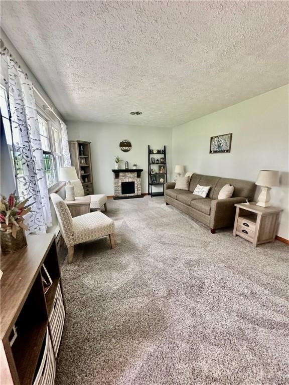 31508 1800 E Rd, Rossville, IL 60963 - living room featuring a textured ceiling, carpet flooring, and a fireplace with raised hearth