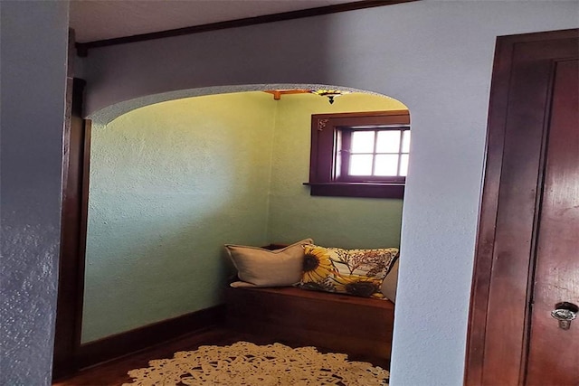 unfurnished room featuring arched walkways and baseboards