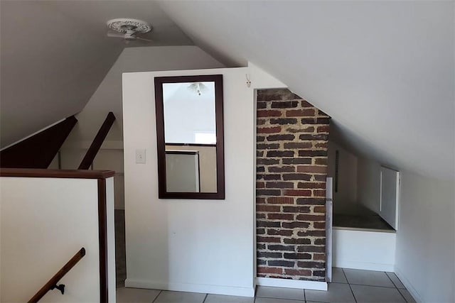 additional living space with tile patterned floors, baseboards, and vaulted ceiling