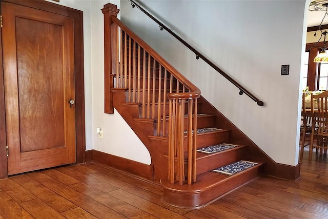 staircase featuring baseboards and hardwood / wood-style flooring