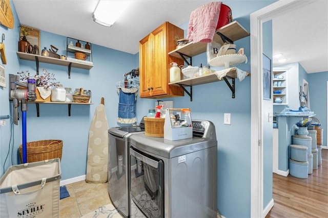 laundry room with baseboards, cabinet space, and washing machine and clothes dryer