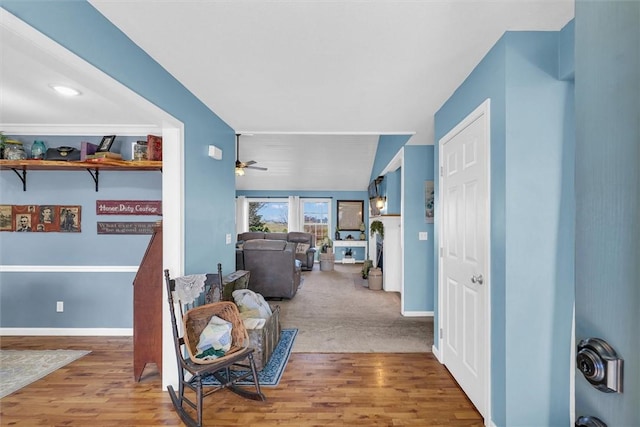 corridor with vaulted ceiling, wood finished floors, and baseboards