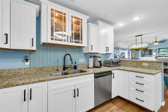 kitchen featuring white cabinetry, a peninsula, ceiling fan, a sink, and stainless steel dishwasher