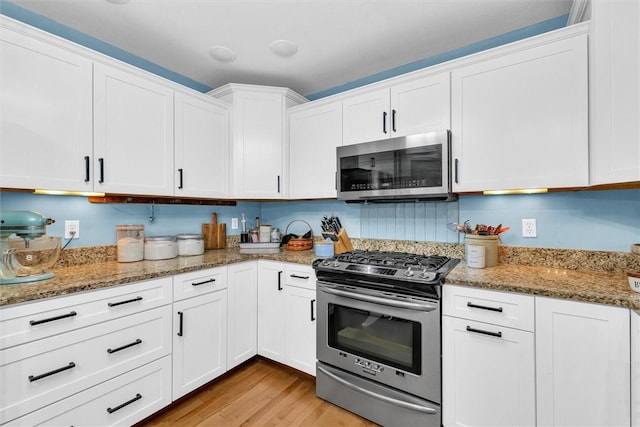 kitchen featuring white cabinetry, light wood-type flooring, and stainless steel appliances