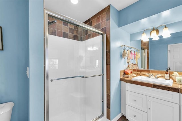 bathroom featuring vanity, toilet, and a stall shower