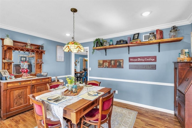 dining room with light wood finished floors, recessed lighting, crown molding, and baseboards