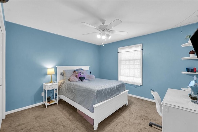 carpeted bedroom with ceiling fan and baseboards