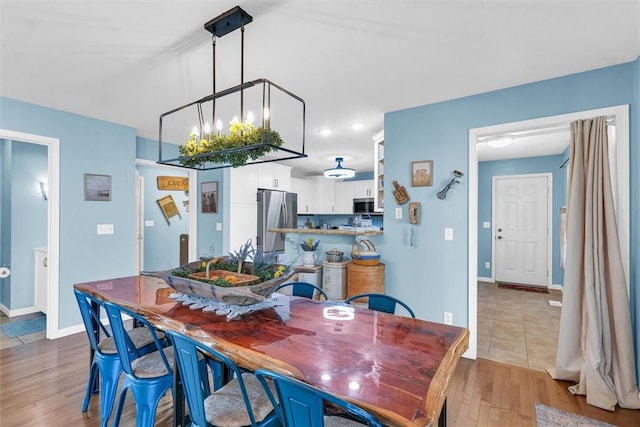 dining area with light wood-style flooring and baseboards