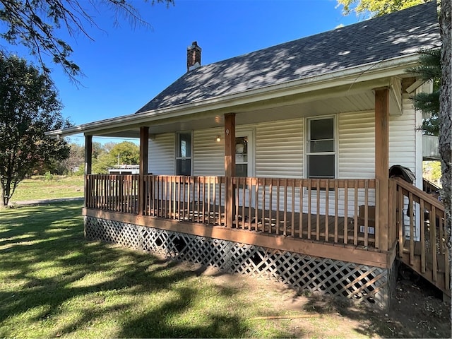 exterior space with covered porch and a lawn