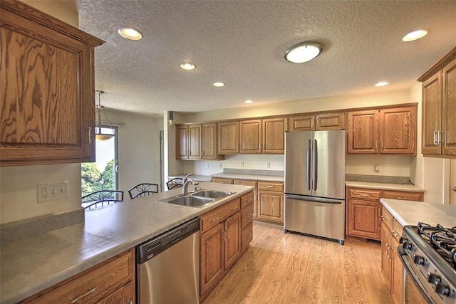 1310 Country Ln, Mt Zion, IL 62549 - kitchen with stainless steel appliances, a textured ceiling, recessed lighting, brown cabinetry, and light wood-style floors