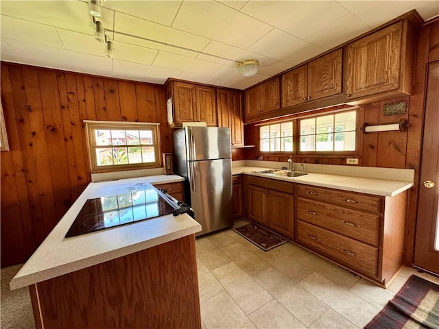 3475 Lake Paradise Rd, Mattoon, IL 61938 - kitchen featuring freestanding refrigerator, light countertops, brown cabinetry, wood walls, and rail lighting