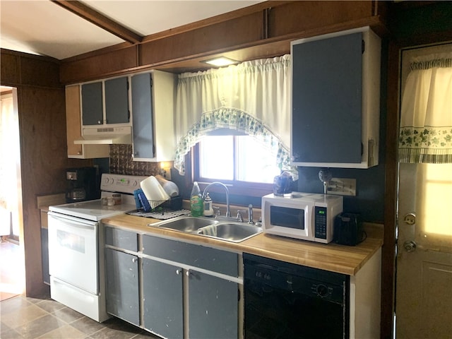 kitchen with white appliances, light countertops, gray cabinetry, under cabinet range hood, and a sink