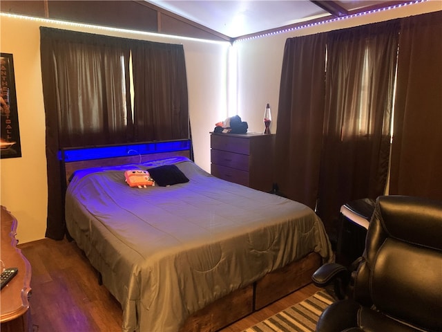 bedroom featuring lofted ceiling and wood finished floors