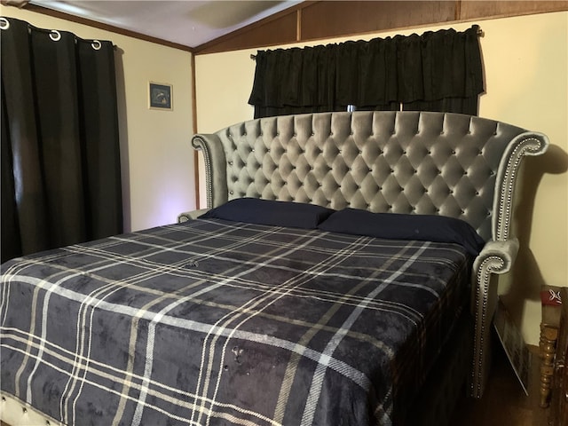 bedroom featuring lofted ceiling and crown molding