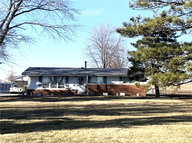 view of front of house with a front yard and brick siding