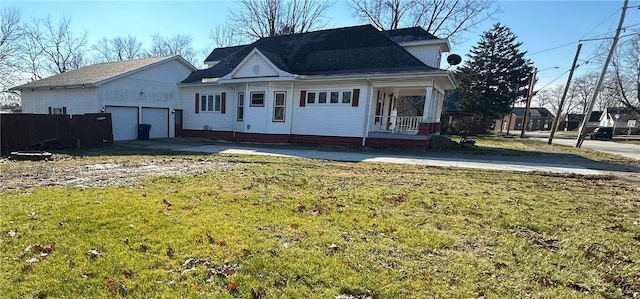 view of front of home with a front yard, a garage, and covered porch