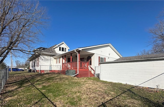 rear view of property featuring a lawn and a porch