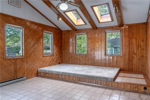 702 N Oakwood St, Effingham, IL 62401 - empty room featuring visible vents, plenty of natural light, vaulted ceiling with skylight, and a baseboard radiator