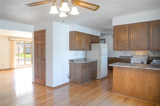 702 N Oakwood St, Effingham, IL 62401 - kitchen with a peninsula, white appliances, light wood-style floors, baseboards, and ceiling fan with notable chandelier