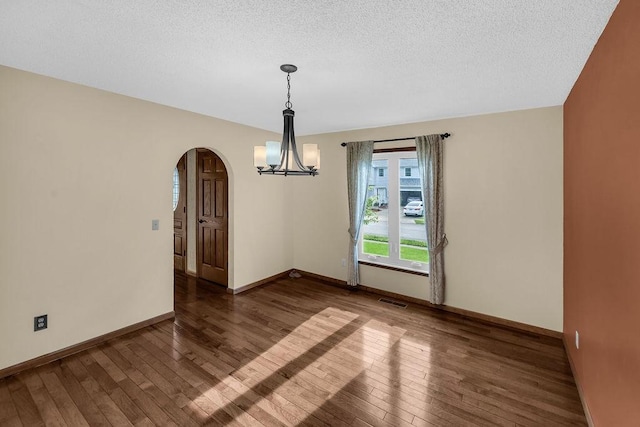 4554 Nicklaus Ct, Decatur, IL 62526 - spare room with arched walkways, hardwood / wood-style floors, a chandelier, baseboards, and a textured ceiling
