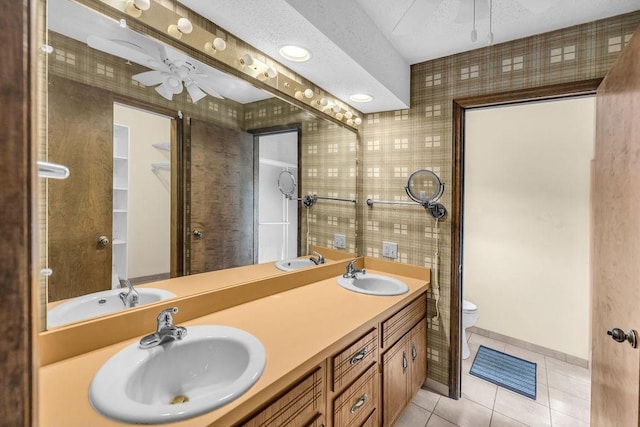 4554 Nicklaus Ct, Decatur, IL 62526 - full bath with toilet, tile patterned floors, a ceiling fan, tile walls, and double vanity