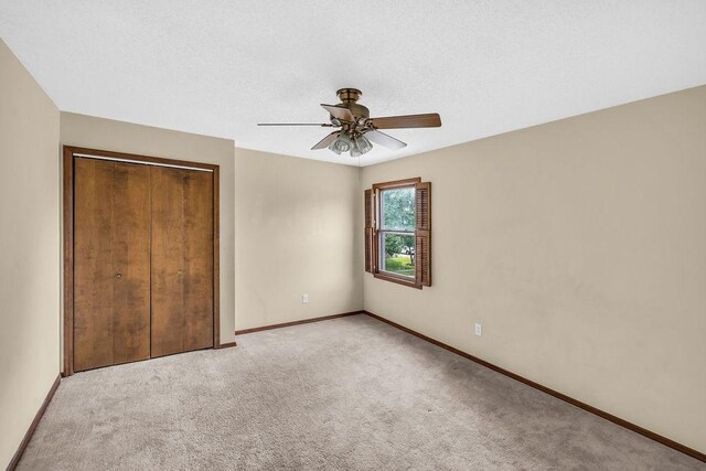 4554 Nicklaus Ct, Decatur, IL 62526 - unfurnished bedroom featuring light colored carpet, baseboards, a closet, and a ceiling fan