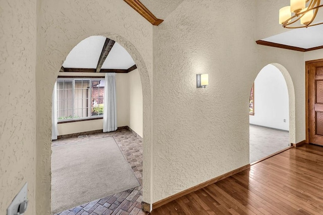 4554 Nicklaus Ct, Decatur, IL 62526 - hall featuring a textured wall, arched walkways, ornamental molding, baseboards, and wood-type flooring